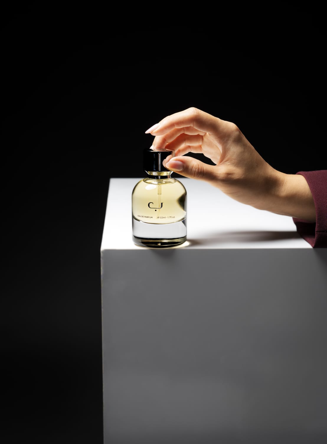 عطر ب من تونكا على قاعدة بيضاء